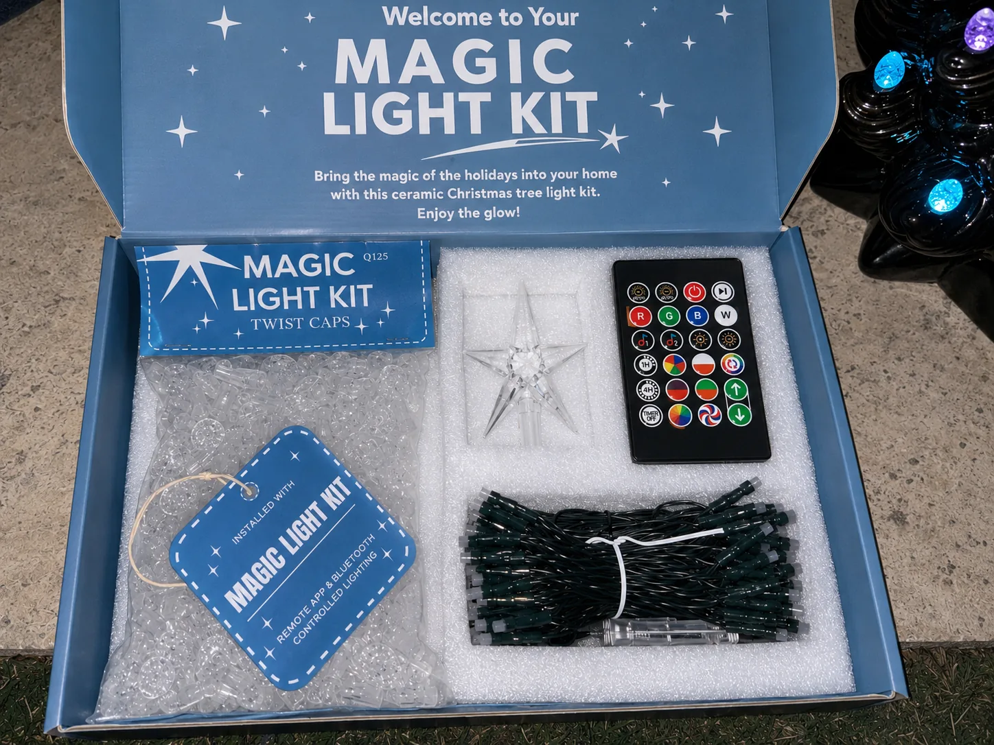 Open Magic Light Kit box showing twist caps, star, remote and LED string